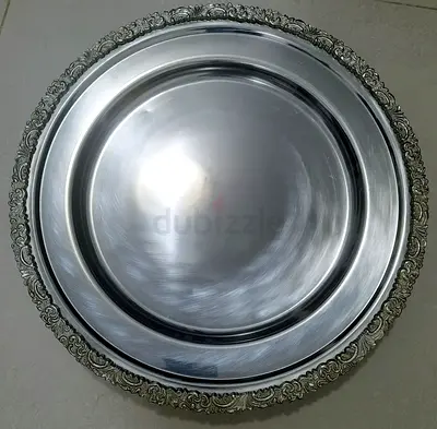 Large round decorative metal serving tray with ornate rim