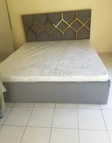 Grey upholstered double bed with decorative headboard - good condition