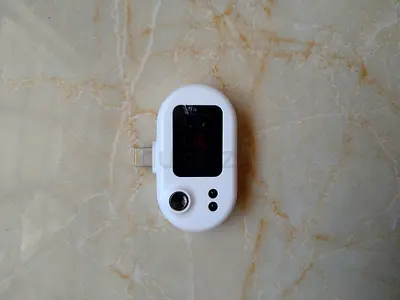 Mobile temperature connector. Compact white mobile accessory with lightning connector and display.