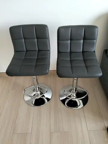 Pair of adjustable grey faux-leather bar stools with chrome base