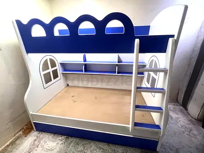Blue and white wooden bunk bed for kids with built-in ladder and shelves