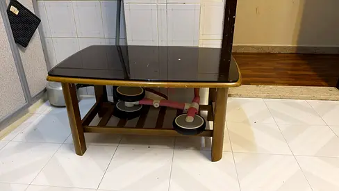 Wooden coffee table with glass top and lower shelf - good condition