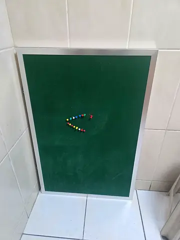 Wall-mounted green felt notice board with aluminium frame