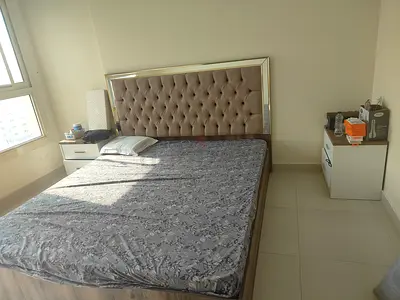 Queen bed with upholstered tufted headboard and two bedside tables - good condition