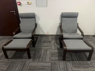 Pair of grey cushioned lounge chairs with ottomans - solid wood frame