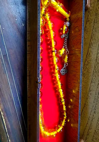 Vintage amber-colored prayer beads (tasbih) in wooden box