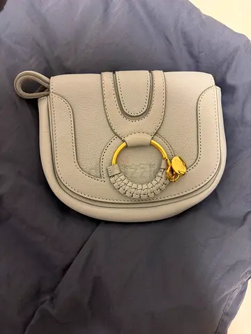 Light grey leather crossbody bag with gold ring detail seebychloe