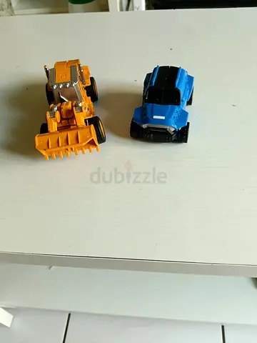 Two small toy vehicles - yellow construction loader and blue pickup car