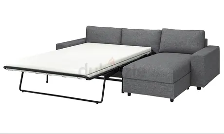 Grey L-shaped sofa bed with chaise lounge — pull-out guest bed