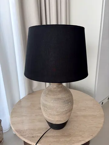 Table lamp with textured ceramic base and black fabric shade