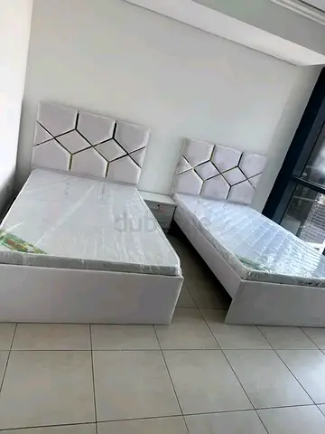 Pair of white single beds with mattresses and nightstand - good condition