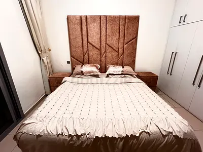 King size upholstered bed with headboard and matching bedside tables