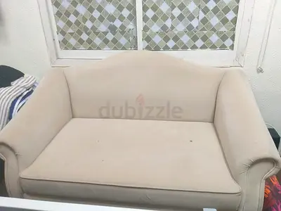 Beige two-seater sofa in good usable condition