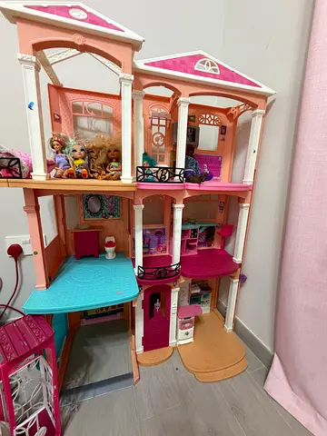 Large pink multi-level Barbie dollhouse with furniture and dolls