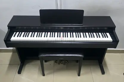 The Yamaha YDP-165R is a premium, full-sized 88-key digital console piano in a matte dark rosewood