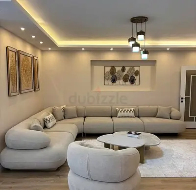 Large L-shaped beige fabric sofa set with matching armchair