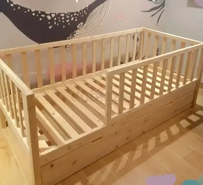 Solid wooden toddler bed with safety rails and storage
