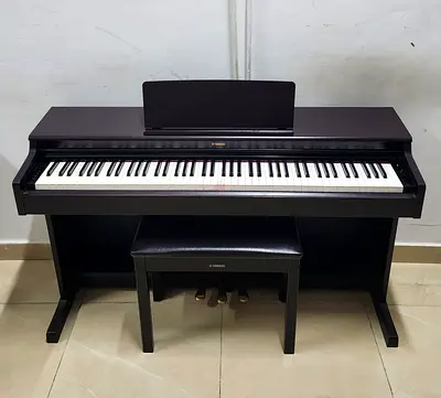 The Yamaha YDP-165R is a premium, full-sized 88-key digital console piano in a matte dark rosewood
