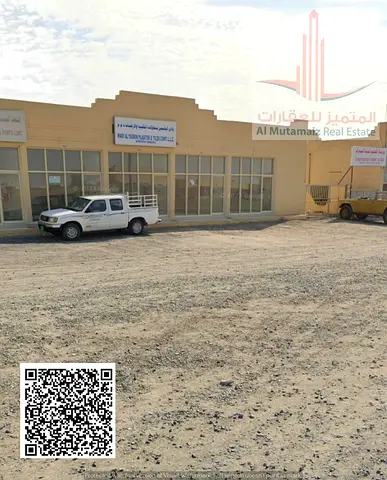 Industrial plot of land in Al-Dhaid; permit includes 5 shops and 2 workshops. Asking price: 800,000.