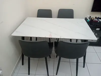 4-seater modern dining table with marble-effect top and grey chairs