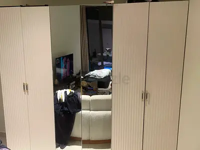 White two-door wardrobe with ribbed doors and brass handles