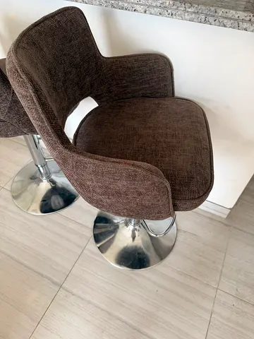 Pair of brown fabric swivel bar stools with chrome bases