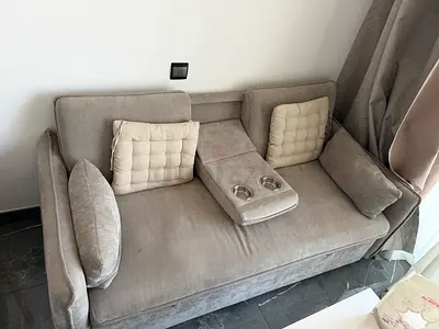 Light grey 2-seater sofa with fold-down center armrest and cup holders