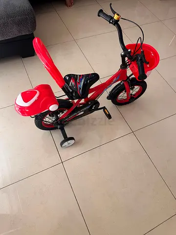 Red kids bicycle with training wheels and rear storage box - good condition