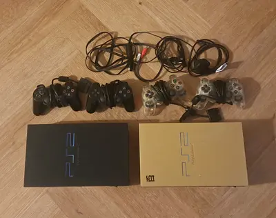 Two Sony PS2 Slim consoles with multiple controllers, cables, games and accessories