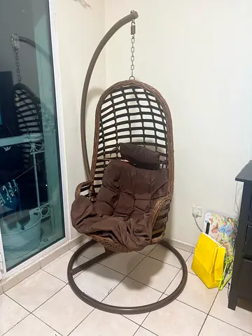 Brown rattan hanging egg chair with stand and cushion