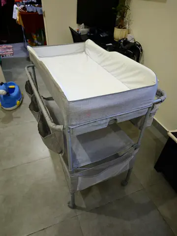 Light grey baby changing table with storage and bassinet top