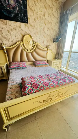 King sized ornate cream wooden bed with headboard and storage bedside tables, dressed Six D cupboard