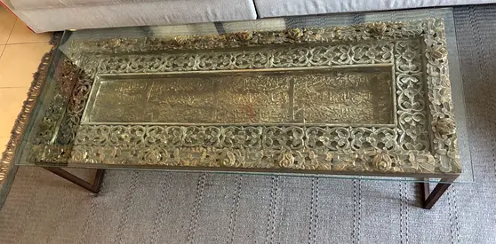 Glass-top carved wooden coffee table with decorative wood inlay