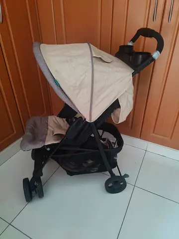 Lightweight beige baby stroller with canopy and cup holder