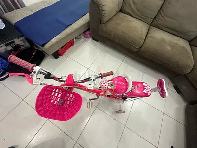 Kids pink bicycle with training wheels and front basket