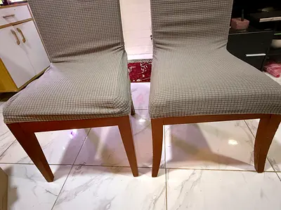Pair of wooden dining chairs with removable grey covers