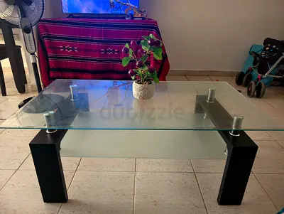 Modern glass top coffee table with black legs — good condition