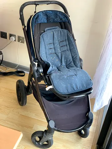 Well-used three-wheel jogging stroller with infant insert