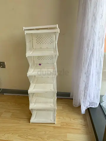 Tall narrow white freestanding storage cabinet with multiple compartments