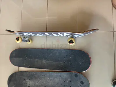 Complete pro skateboard with two extra decks of varying sizes.