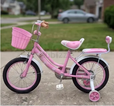 Girls pink 14-inch bike with training wheels and basket - good condition