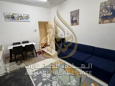 Room/living area, fully furnished, utilities included, located near the Dubai exit, Al Taawun, Shar
