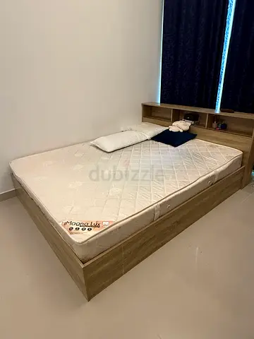 Wooden double bed frame with mattress and built-in headboard shelving