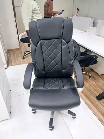 Black ergonomic reclining office gaming chair with footrest