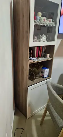 Tall wooden display cabinet with glass door and storage drawers