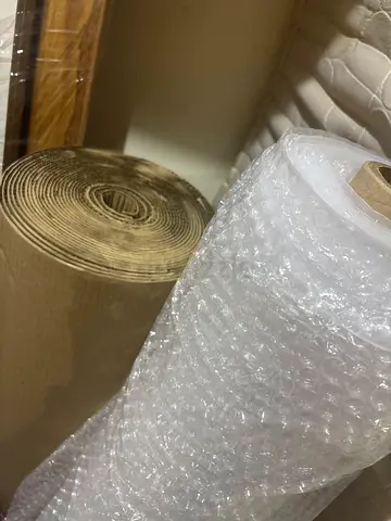 Large rolls of bubble wrap and kraft paper for packing — bulk