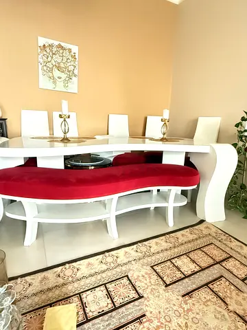 White Curved Dining Table with Red Upholstered Benches and Side Chairs