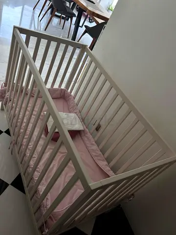 White wooden baby crib with pink mattress and bumper - good condition