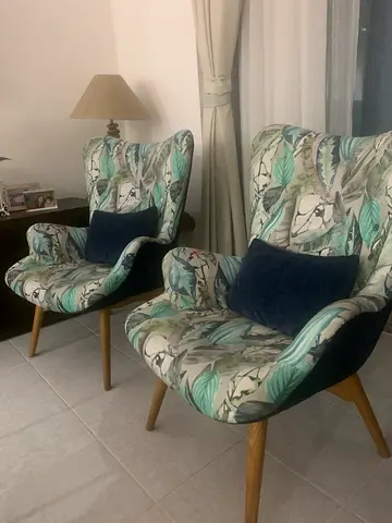 Pair of patterned accent chairs with wooden legs and nested teapoy