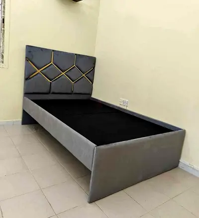 Single grey upholstered bed frame with decorative headboard